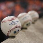 three white baseballs on gray textile